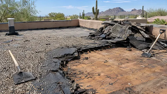 Old tar and gravel flat roof partly torn off down to the wood deck on an Arizona home